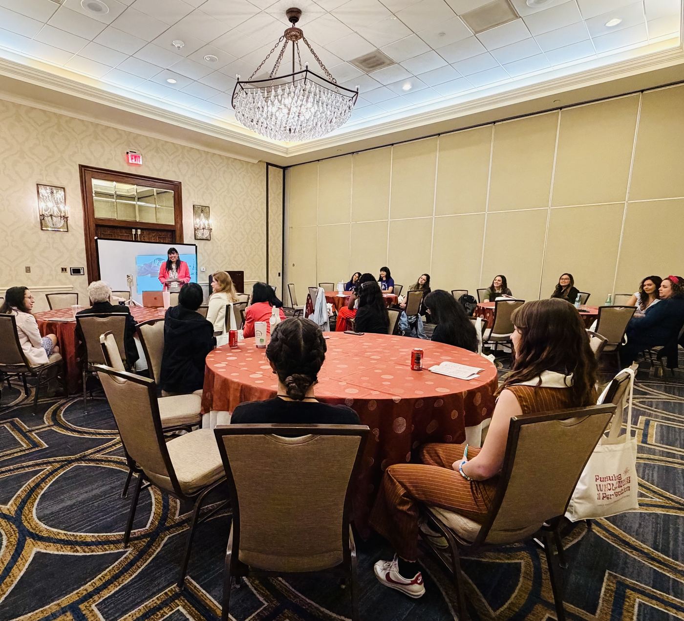 Holly Subervi leading a workshop for leaders seated at round tables